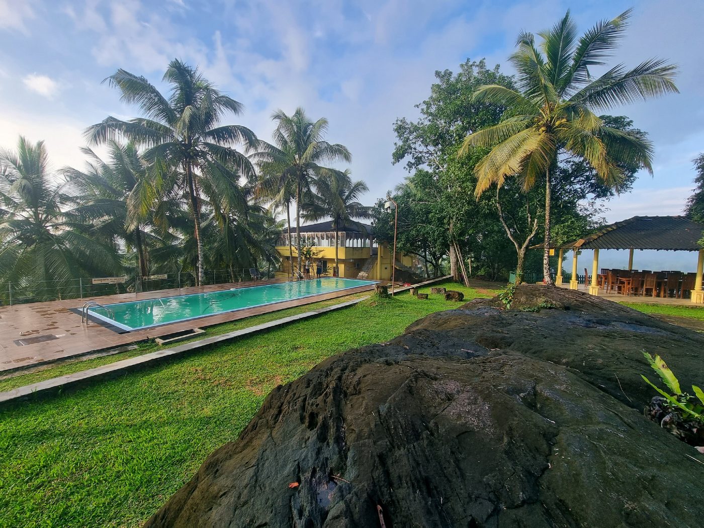 Swimming pool, open lawn and guest buildings across the property